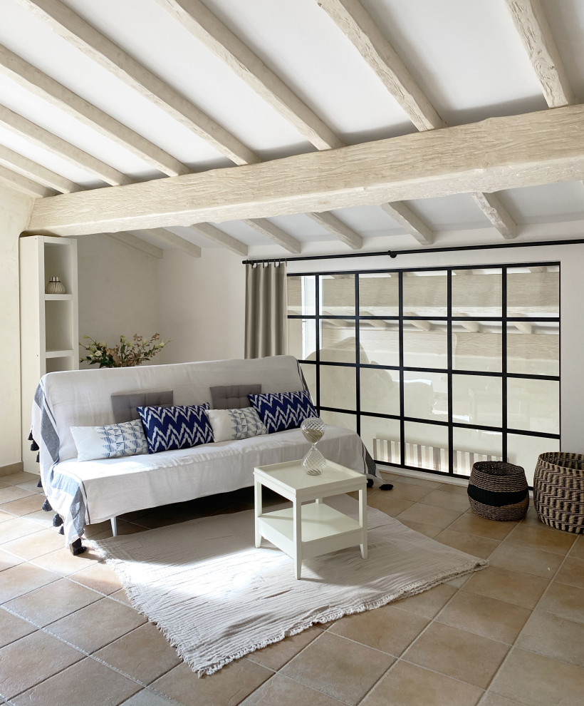 Photo of a large beach style guest bedroom in Nice with blue walls, terra-cotta floors, no fireplace and beige floor.