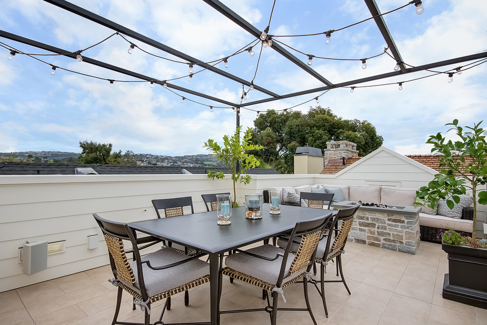 This is an example of a mid-sized traditional rooftop and rooftop deck in Orange County with a fire feature and a pergola.