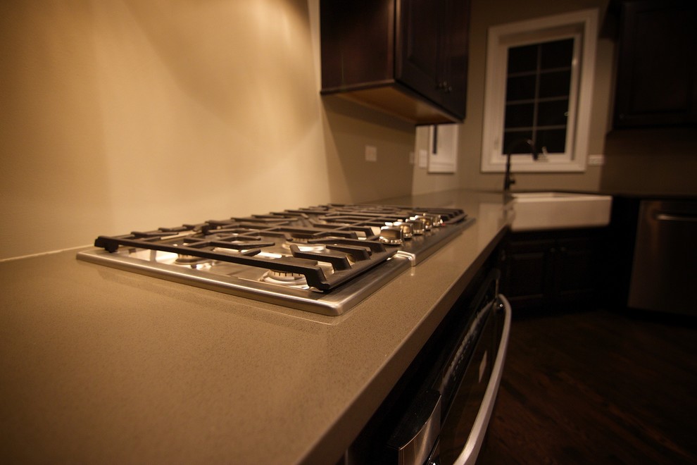 Enclosed kitchen - mid-sized transitional single-wall dark wood floor enclosed kitchen idea in Chicago with recessed-panel cabinets, white cabinets, solid surface countertops, white backsplash, porcelain backsplash, stainless steel appliances, an island and a farmhouse sink