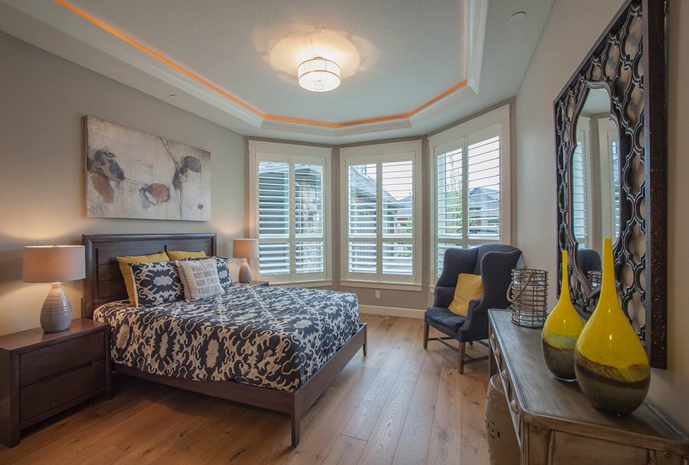 Design ideas for a transitional master bedroom in Portland with grey walls and light hardwood floors.