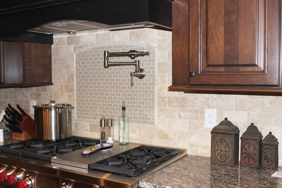 Kitchen - mid-sized rustic dark wood floor kitchen idea in Cedar Rapids with raised-panel cabinets, dark wood cabinets, granite countertops, stainless steel appliances, beige backsplash and stone tile backsplash