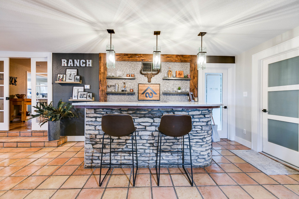 Photo of a mid-sized transitional home bar in Austin with no sink, open cabinets, quartzite benchtops, grey splashback, terra-cotta floors, orange floor and white benchtop.
