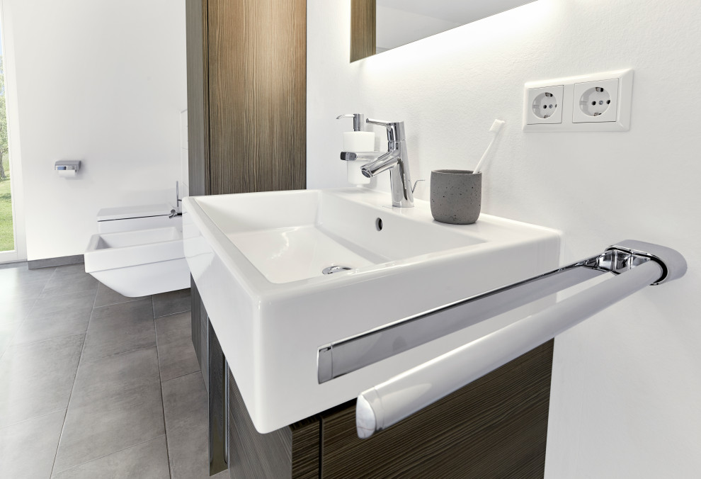 Large contemporary 3/4 bathroom in Frankfurt with flat-panel cabinets, brown cabinets, a wall-mount toilet, white tile, porcelain tile, white walls, porcelain floors, a wall-mount sink, wood benchtops, white benchtops, an enclosed toilet, a single vanity, a floating vanity and grey floor.