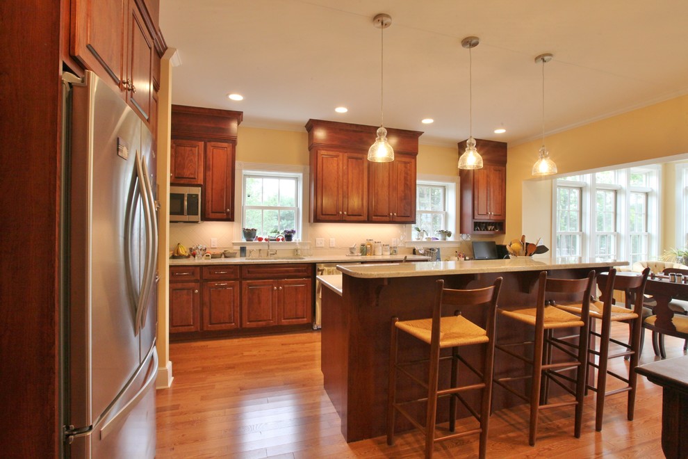 Inspiration for a large modern light wood floor and brown floor eat-in kitchen remodel with a drop-in sink, dark wood cabinets, granite countertops, stainless steel appliances and an island