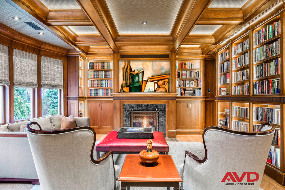 This is an example of a large traditional enclosed family room in Boston with a library, a concealed tv, brown walls, light hardwood floors, a standard fireplace, a tile fireplace surround and beige floor.