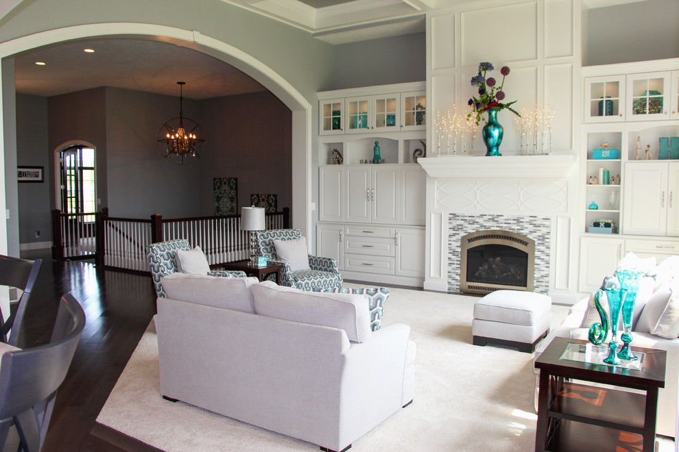 Expansive traditional open concept family room in Other with grey walls, carpet, a standard fireplace, a tile fireplace surround and a concealed tv.