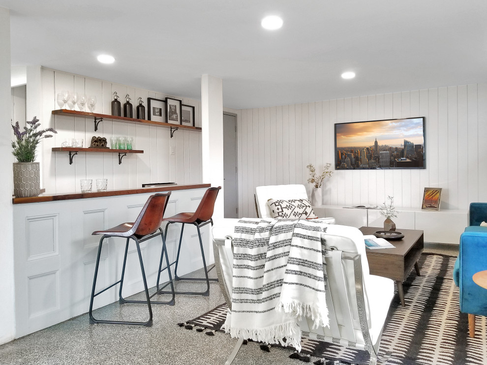 Idée de décoration pour un sous-sol design semi-enterré avec un bar de salon, un mur blanc, un sol gris et du lambris.