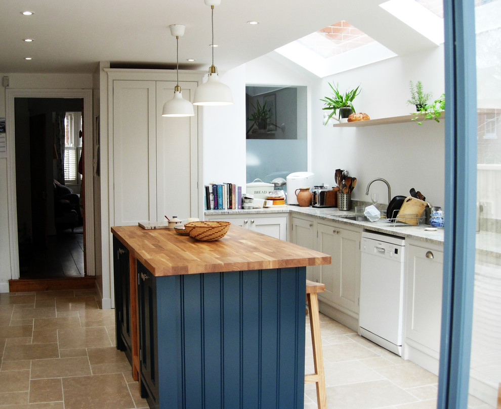 This is an example of a small traditional single-wall eat-in kitchen in London with shaker cabinets, grey cabinets, wood benchtops, ceramic floors, with island and beige floor.