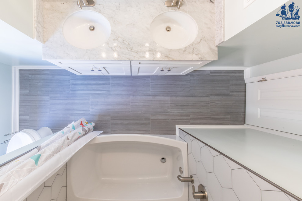 Идея дизайна: маленькая детская ванная комната в современном стиле с фасадами с утопленной филенкой, белыми фасадами, ванной в нише, керамической плиткой, серыми стенами, полом из керамической плитки, врезной раковиной, столешницей из гранита, душем над ванной, писсуаром, белой плиткой, серым полом, шторкой для ванной и разноцветной столешницей для на участке и в саду