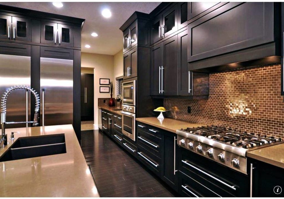 Example of a mid-sized transitional single-wall dark wood floor kitchen design in Chicago with shaker cabinets, dark wood cabinets, an island, a double-bowl sink, limestone countertops, brown backsplash, mosaic tile backsplash and stainless steel appliances