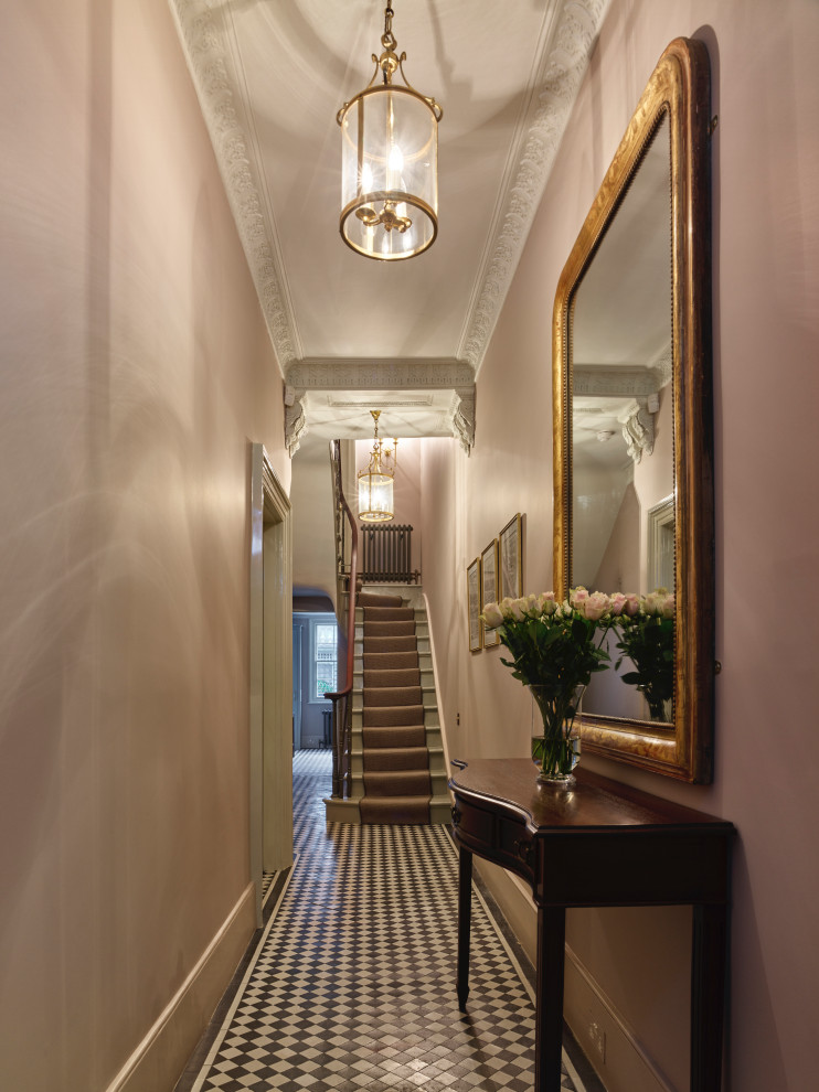 Large victorian hallway in London with pink walls, porcelain flooring, a single front door and a black front door.