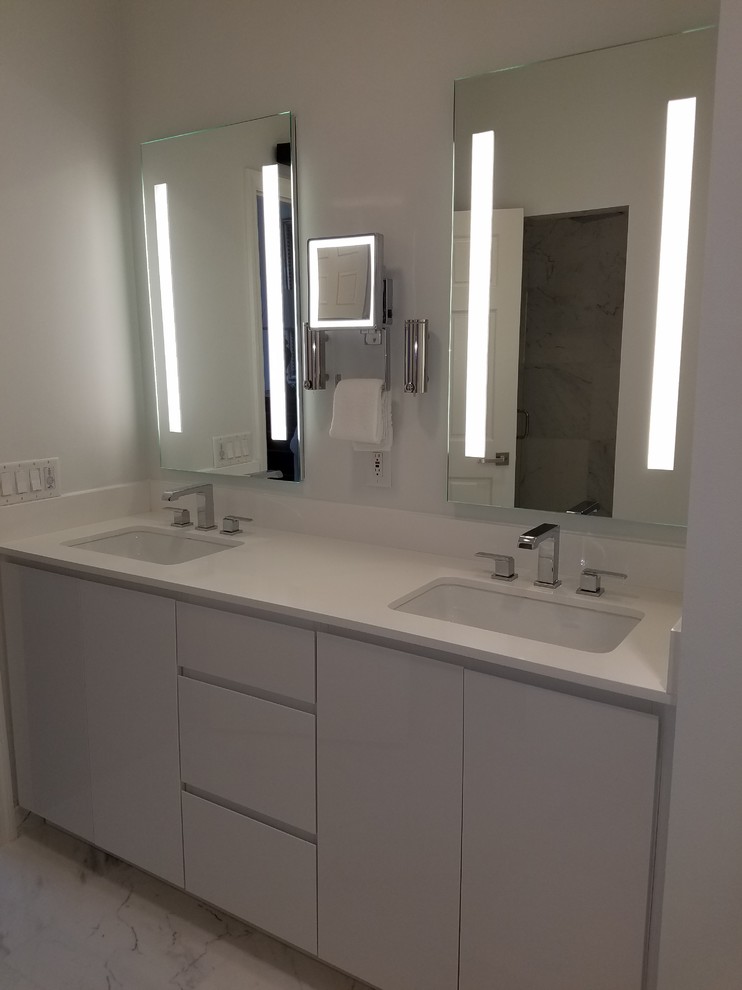 Example of a small transitional master white tile and marble tile marble floor and white floor double shower design in Miami with flat-panel cabinets, white cabinets, a one-piece toilet, blue walls, an undermount sink, quartz countertops and a hinged shower door