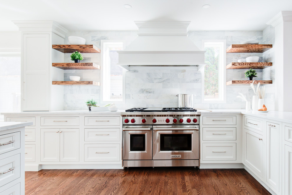 Open concept kitchen - mid-sized transitional u-shaped medium tone wood floor and brown floor open concept kitchen idea with a farmhouse sink, recessed-panel cabinets, white cabinets, quartz countertops, multicolored backsplash, marble backsplash, stainless steel appliances, a peninsula and white countertops