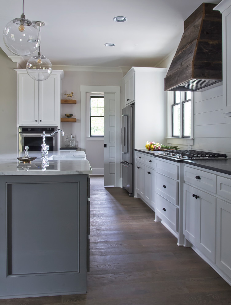 Inspiration for a mid-sized country l-shaped open plan kitchen in Atlanta with a farmhouse sink, recessed-panel cabinets, white cabinets, quartz benchtops, white splashback, timber splashback, stainless steel appliances, medium hardwood floors, with island and brown floor.