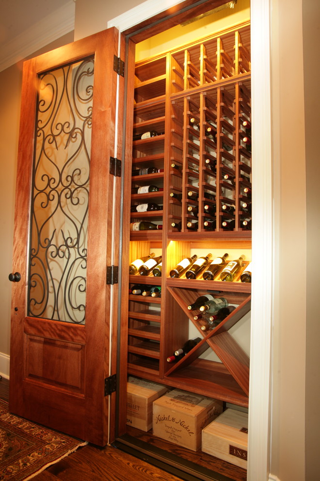 Photo of a small traditional wine cellar in Charleston with medium hardwood floors, storage racks and brown floor.