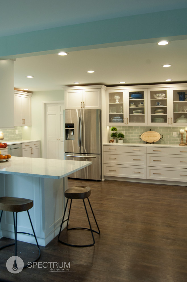 Mid-sized transitional u-shaped medium tone wood floor eat-in kitchen photo in Chicago with a drop-in sink, raised-panel cabinets, white cabinets, granite countertops, green backsplash, subway tile backsplash, stainless steel appliances and an island