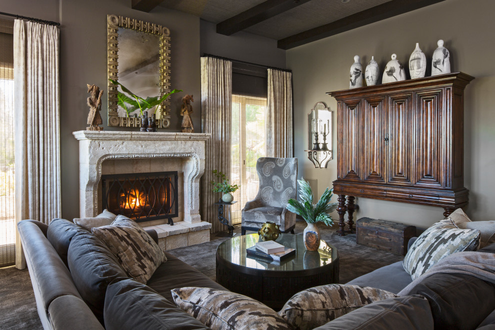 Inspiration for a mediterranean family room in Los Angeles with grey walls, carpet, a standard fireplace, a stone fireplace surround, a concealed tv, grey floor and exposed beam.