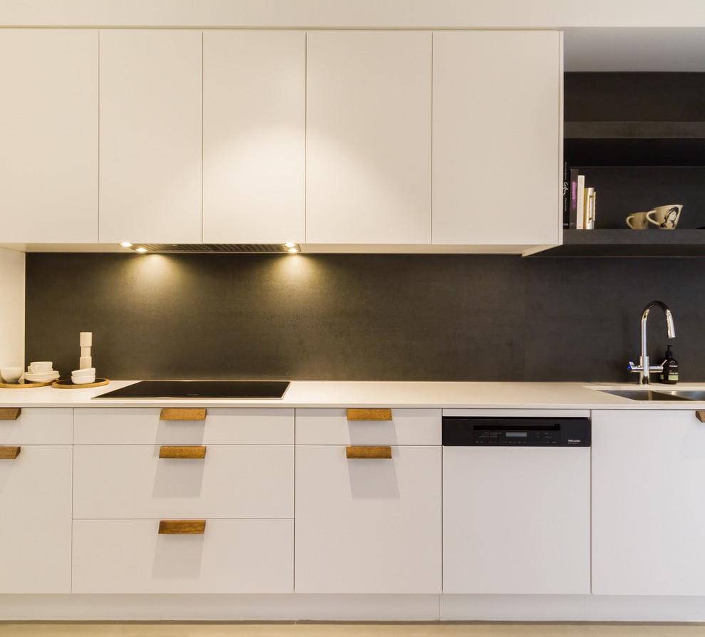 Design ideas for a large modern l-shaped open plan kitchen in Melbourne with an undermount sink, flat-panel cabinets, white cabinets, marble benchtops, grey splashback, marble splashback, black appliances, medium hardwood floors, with island, brown floor and grey benchtop.