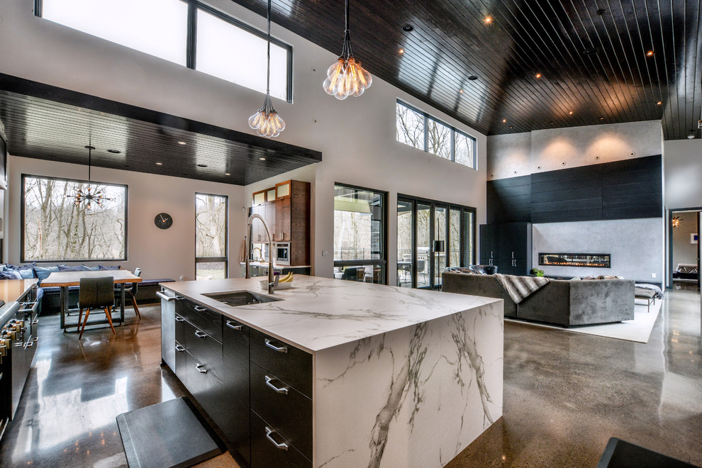Open concept kitchen - large contemporary l-shaped concrete floor and gray floor open concept kitchen idea with an undermount sink, flat-panel cabinets, dark wood cabinets, quartz countertops, gray backsplash, stone tile backsplash, stainless steel appliances and an island