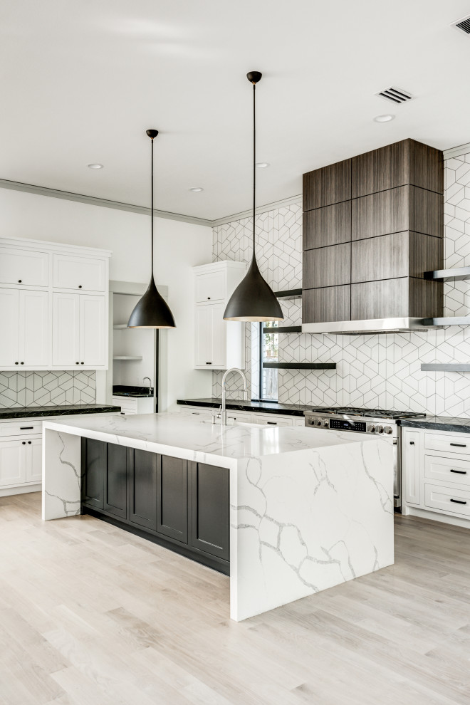 Inspiration for a transitional l-shaped open plan kitchen in Dallas with a farmhouse sink, shaker cabinets, white cabinets, quartz benchtops, white splashback, ceramic splashback, stainless steel appliances, light hardwood floors, with island, white floor and white benchtop.