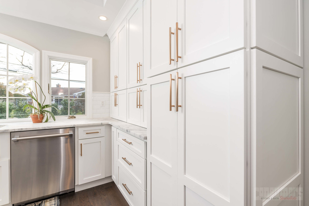 Large u-shaped eat-in kitchen in New York with a farmhouse sink, recessed-panel cabinets, white cabinets, quartzite benchtops, white splashback, ceramic splashback, stainless steel appliances, plywood floors and with island.