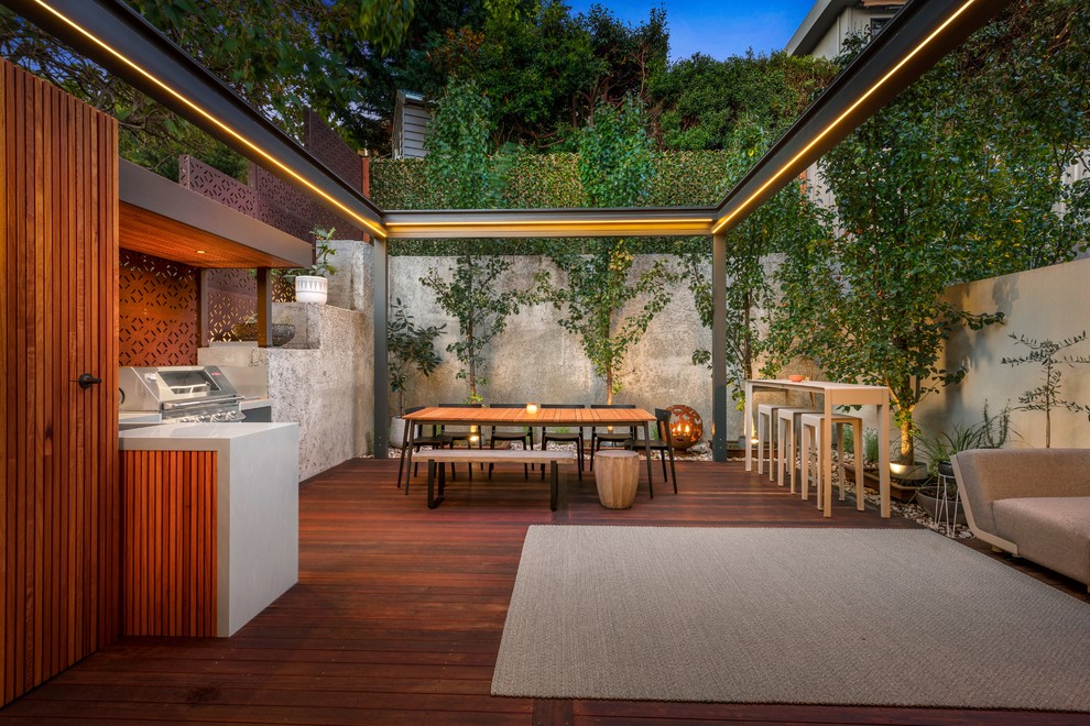 This is an example of a mid-sized contemporary backyard deck in Melbourne with an outdoor kitchen and no cover.