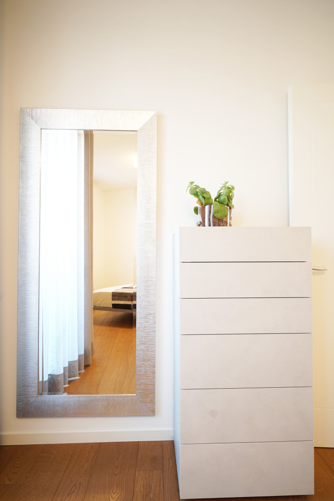 Aménagement d'une chambre parentale contemporaine de taille moyenne avec un mur blanc et parquet clair.