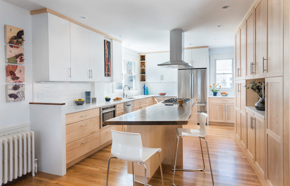 Transitional u-shaped kitchen in Boston with an undermount sink, shaker cabinets, medium wood cabinets, wood benchtops, white splashback, subway tile splashback, stainless steel appliances, medium hardwood floors, with island, brown floor and brown benchtop.