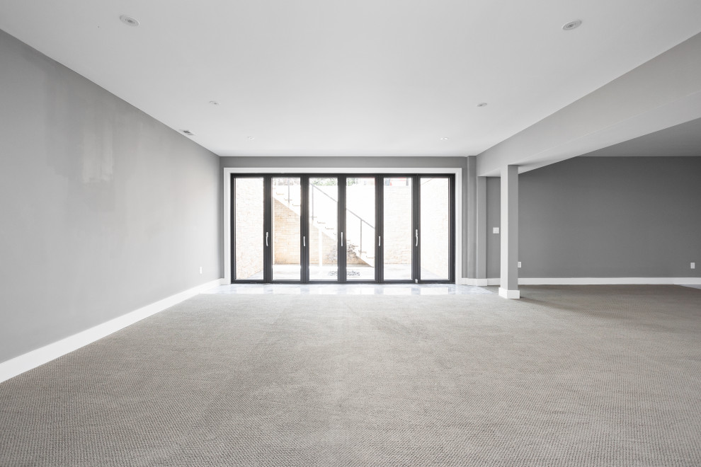 Idéer för att renovera en mycket stor funkis källare ovan mark, med en hemmabar, grå väggar, heltäckningsmatta och grått golv