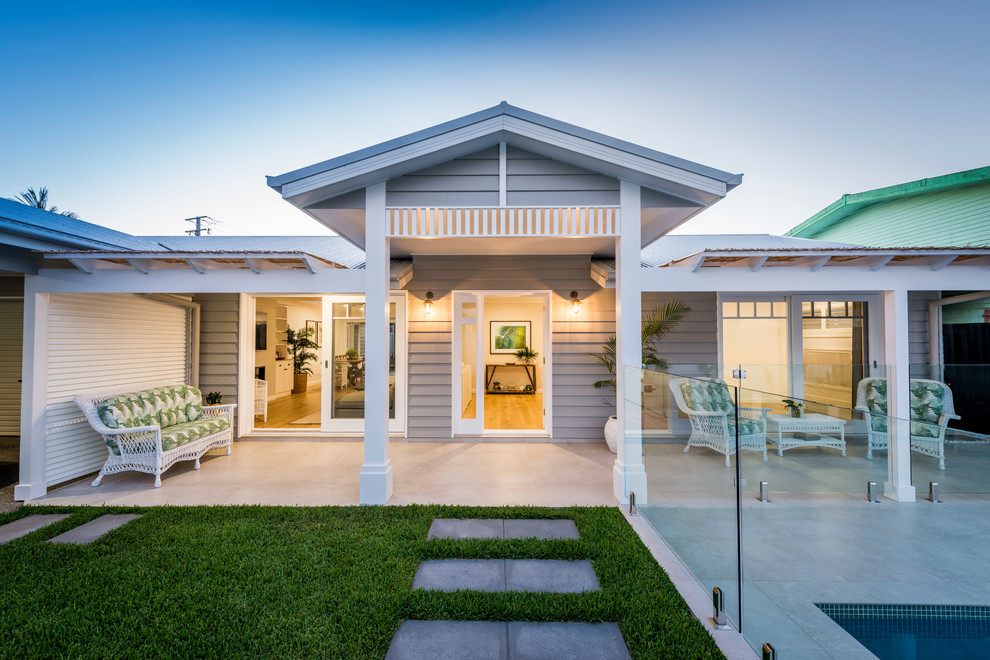 Inspiration for a mid-sized beach style front yard verandah in Gold Coast - Tweed with a pergola and tile.
