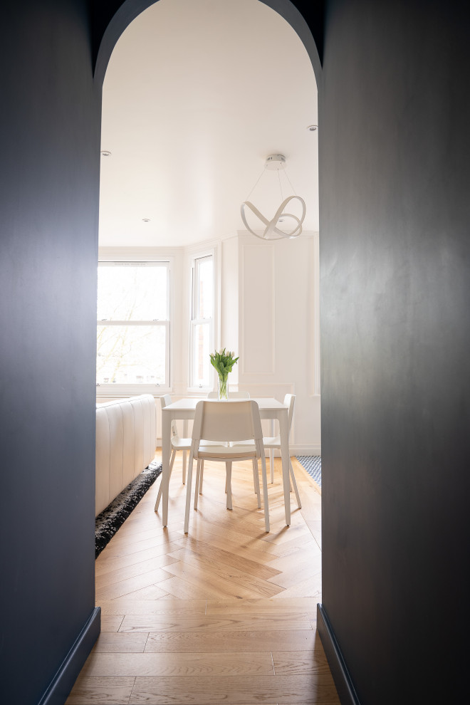 Cette image montre un petit couloir minimaliste avec parquet clair et un sol marron.