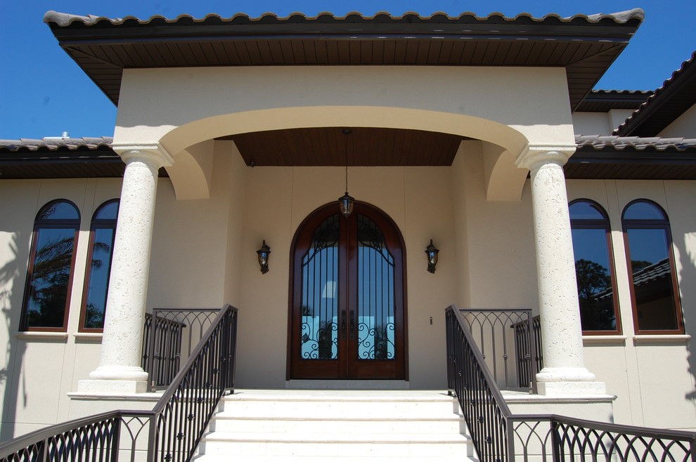 Example of a large mountain style front door design in Miami with beige walls and a dark wood front door