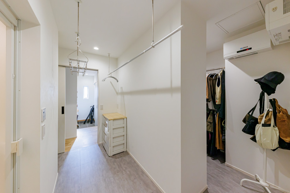 Photo of a mid-sized modern laundry room in Kobe with wallpaper and wallpaper.