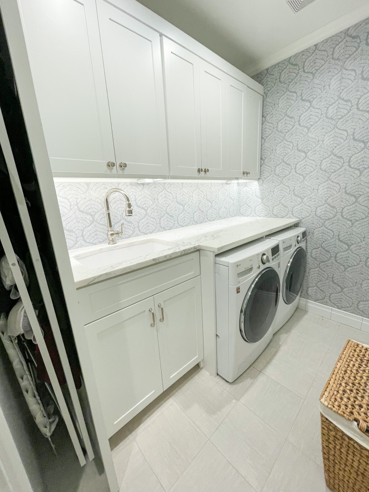 This is an example of a small classic single-wall separated utility room in Dallas with an utility sink, shaker cabinets, white cabinets, marble worktops, blue splashback, ceramic splashback, blue walls, porcelain flooring, a side by side washer and dryer, beige floors and white worktops.