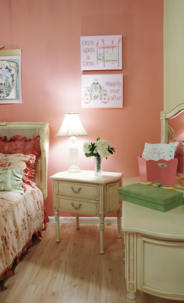 Inspiration for a traditional kids' bedroom for kids 4-10 years old and girls in Miami with pink walls and light hardwood floors.