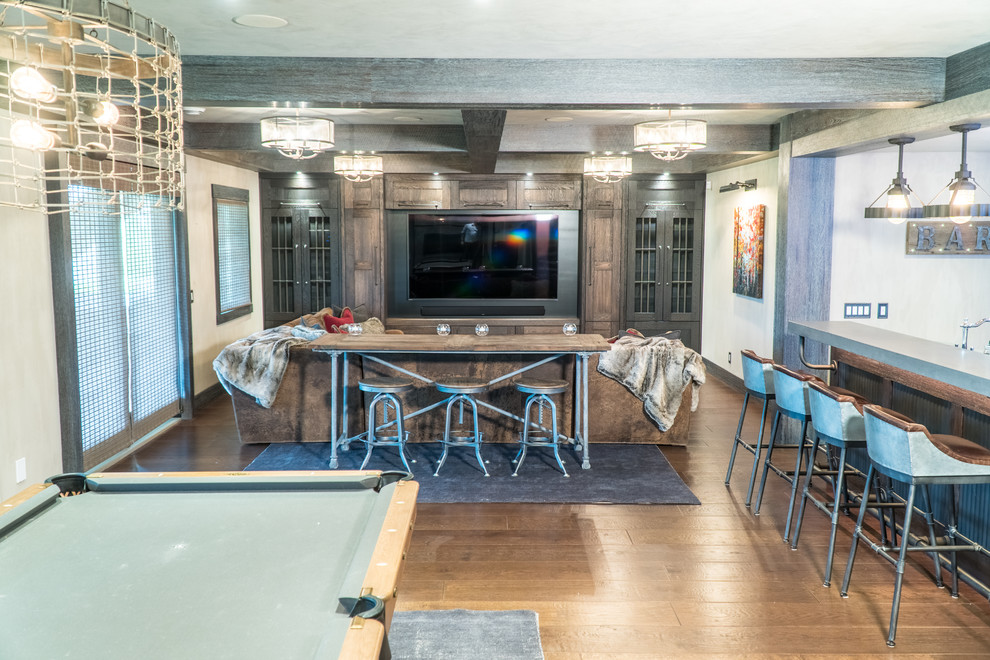 Example of a large mountain style walk-out medium tone wood floor and brown floor basement design in Calgary with gray walls