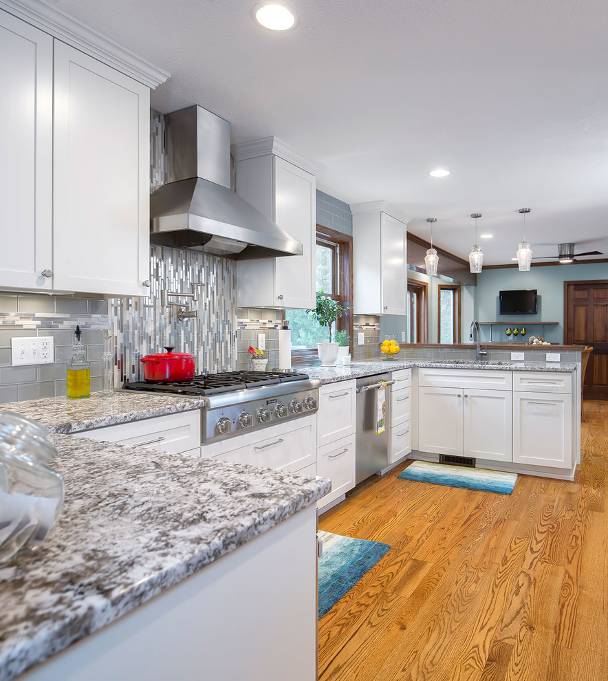 Huge transitional medium tone wood floor eat-in kitchen photo in Minneapolis with an undermount sink, shaker cabinets, dark wood cabinets, granite countertops, multicolored backsplash, stone tile backsplash, stainless steel appliances and a peninsula