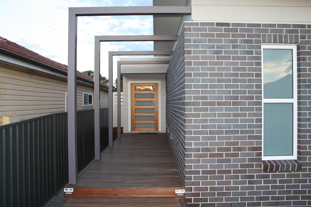 Mid-sized contemporary one-storey brick grey exterior in Newcastle - Maitland with a flat roof.