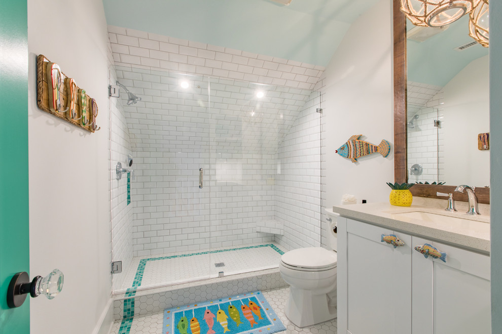 Tropical 3/4 bathroom in Miami with shaker cabinets, white cabinets, an alcove shower, a two-piece toilet, white tile, subway tile, white walls, mosaic tile floors, an undermount sink, white floor and a sliding shower screen.