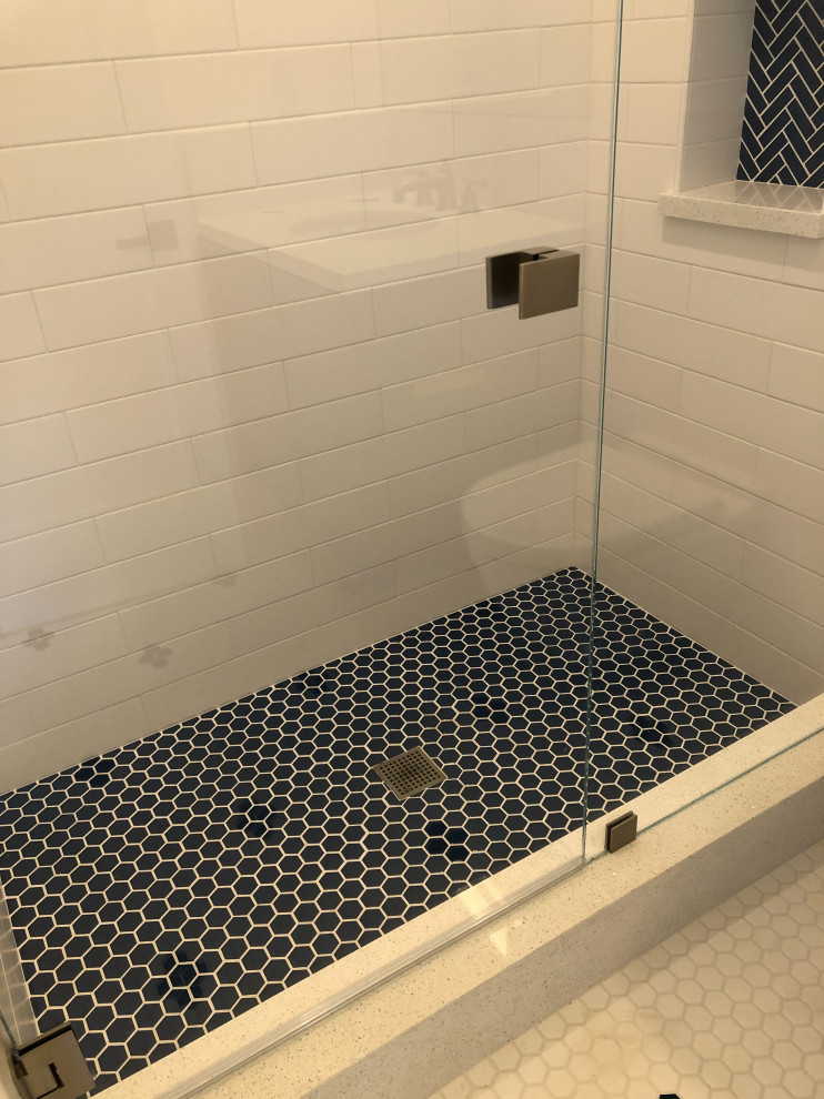 Photo of a small beach style master bathroom in San Francisco with shaker cabinets, blue cabinets, a wall-mount toilet, white tile, ceramic tile, white walls, ceramic floors, a wall-mount sink, engineered quartz benchtops, blue floor, white benchtops, a niche, a single vanity and a floating vanity.