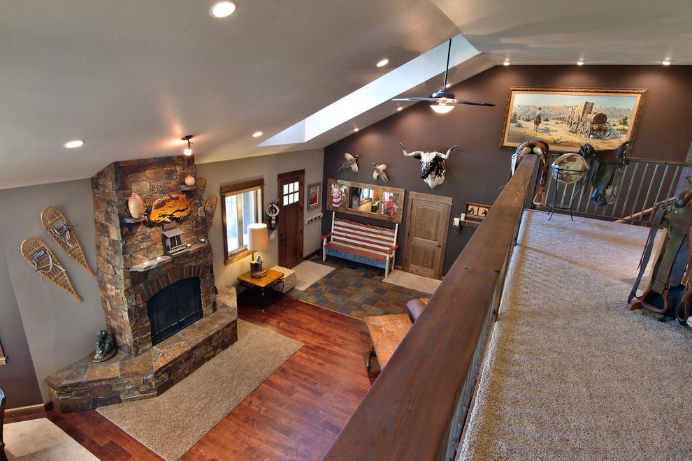 Inspiration for a mid-sized country open concept living room in Other with beige walls, dark hardwood floors, a standard fireplace, a stone fireplace surround and brown floor.
