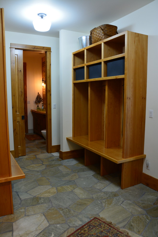 Photo of a large country gender-neutral walk-in wardrobe in Denver with brown cabinets, limestone floors and multi-coloured floor.