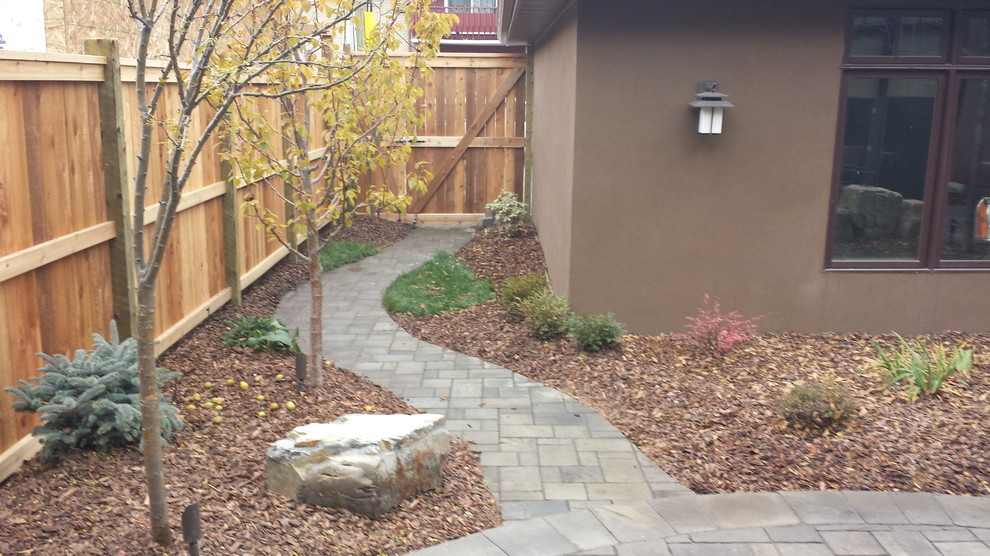 This is an example of a mid-sized contemporary backyard partial sun garden for summer in Calgary with concrete pavers.