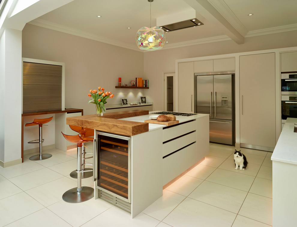 Inspiration for a large contemporary open plan kitchen in London with an undermount sink, flat-panel cabinets, white cabinets, quartz benchtops, glass sheet splashback, stainless steel appliances and with island.