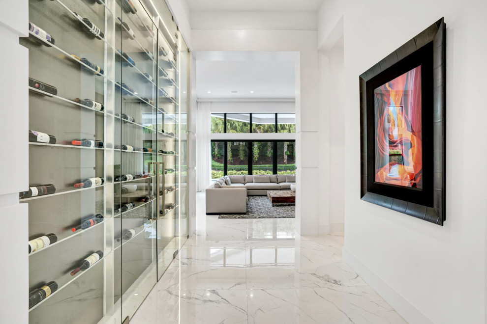 This is an example of a mid-sized contemporary wine cellar in Miami with porcelain floors, display racks and white floor.