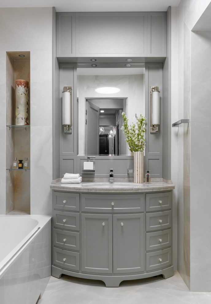 Ejemplo de cuarto de baño único y de pie tradicional renovado con armarios con paneles empotrados, puertas de armario grises, bañera empotrada, combinación de ducha y bañera, paredes grises, lavabo encastrado, suelo gris y encimeras grises