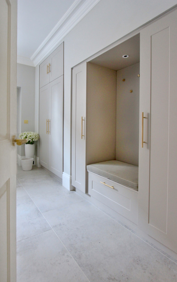 Cette photo montre un grand WC et toilettes tendance avec un placard à porte shaker, des portes de placard grises, un mur blanc et un sol gris.