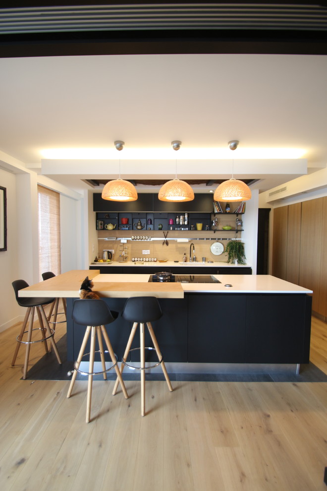 This is an example of a contemporary kitchen in Nantes with open cabinets, beige splashback, light hardwood floors, with island, beige floor and white benchtop.