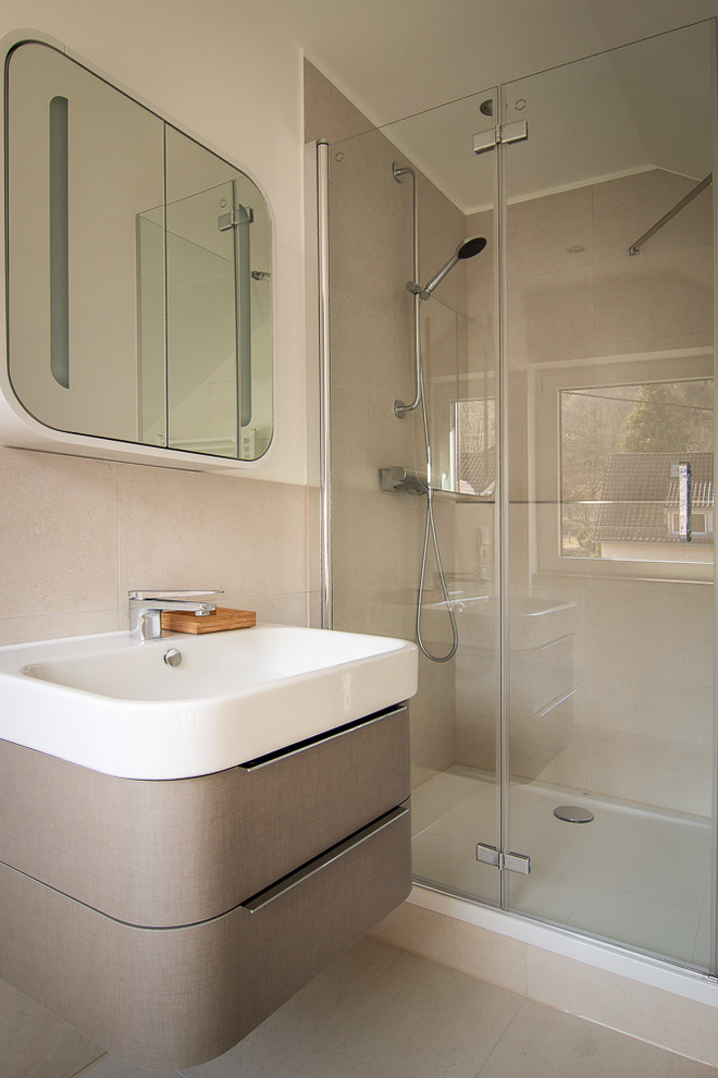 Duschbad With flächenbündigen Schrankfronten, grauen Schränken, Duschnische, beigen Fliesen, weißer Wandfarbe, Waschtischkonsole, beigem Boden, Falttür-Duschabtrennung, Keramikfliesen, Keramikboden and Mineralwerkstoff-Waschtisch in Stuttgart