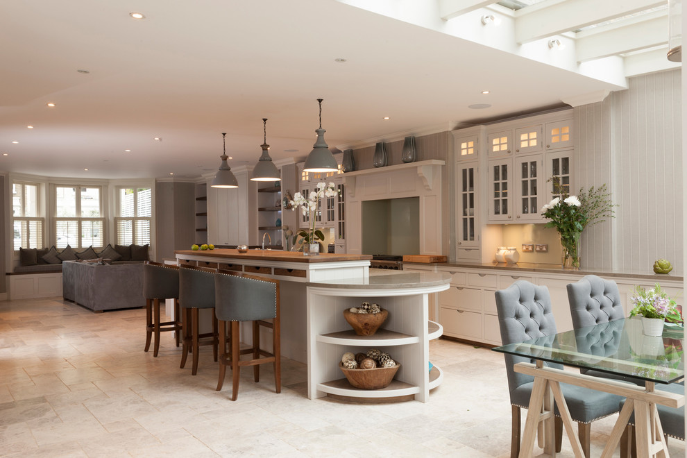 Photo of a large traditional galley eat-in kitchen in London with a farmhouse sink, grey cabinets, granite benchtops, green splashback, glass sheet splashback, stainless steel appliances, shaker cabinets, porcelain floors and with island.